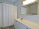 Bathroom featuring a single sink, vanity with storage, decorative mirror, and a shower with a white shower curtain at 64 Summerlight Dr., Murrells Inlet, SC 29576