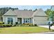 Charming single-story home with well-manicured lawn and colorful flowerbeds leading to an attached two-car garage at 64 Summerlight Dr., Murrells Inlet, SC 29576