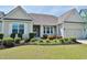 Charming home featuring a well-manicured front yard with colorful flower beds, and a covered front entry at 64 Summerlight Dr., Murrells Inlet, SC 29576