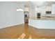 Bright kitchen featuring granite countertops, stainless steel appliances, white cabinetry, and hardwood floors at 64 Summerlight Dr., Murrells Inlet, SC 29576