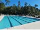 Community pool featuring multiple lap lanes, lounge chairs, and mature trees providing a refreshing retreat at 64 Summerlight Dr., Murrells Inlet, SC 29576