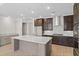 Spacious kitchen featuring an oversized island with a wine rack, stainless appliances, gas range and dark cabinetry at 377 Starlit Way, Myrtle Beach, SC 29579