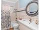 Bright bathroom featuring a shower-tub combo, single vanity and a large round mirror at 460 Boundary Ave., Murrells Inlet, SC 29576