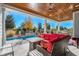 Back porch with wood ceiling, fire pit, stone waterfall and view of fenced in back yard with swimming pool at 6105 Bolsena Place, Myrtle Beach, SC 29577