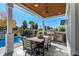 Back porch with wood ceiling, dining table, stone waterfall and view of fenced in back yard with swimming pool at 6105 Bolsena Place, Myrtle Beach, SC 29577