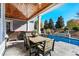 Back porch with wood ceiling, dining table, stone waterfall and view of fenced in back yard with swimming pool at 6105 Bolsena Place, Myrtle Beach, SC 29577