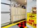 Organized garage with custom cabinets, wall decor, and a checkered floor, ideal for storage and projects at 6105 Bolsena Place, Myrtle Beach, SC 29577