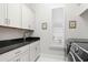 The laundry room boasts modern appliances, cabinets, a sink and natural light from the window at 6105 Bolsena Place, Myrtle Beach, SC 29577