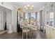 A bright and airy dining room featuring a modern chandelier and elegant table setting for four at 724 Hobonny Loop, Longs, SC 29568