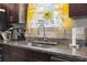 Close up of a kitchen sink area with granite countertops and a window with yellow floral curtains at 724 Hobonny Loop, Longs, SC 29568