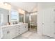 Bright bathroom with double vanity, gray tile and a glass-enclosed shower with bench at 561 Slaty Dr., Myrtle Beach, SC 29588