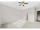 Bedroom with carpet, tray ceilings, ceiling fan, and an attached bathroom with stairs nearby at 1711 Sapphire Dr., Longs, SC 29568
