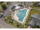 Aerial view of a community pool with palm trees, seating, and an umbrella at 1711 Sapphire Dr., Longs, SC 29568