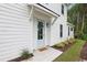 Charming home entrance with light blue door, white siding, manicured lawn, and tidy landscape at 2400 Hillbourne Loop, North Myrtle Beach, SC 29582