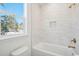 The white bathtub features a beige-tiled wall with built-in storage and a shower at 2624 Hillbourne Loop, North Myrtle Beach, SC 29582