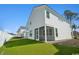 White home exterior showcasing a screened-in porch, lush lawn, and modern design elements for outdoor living at 2624 Hillbourne Loop, North Myrtle Beach, SC 29582