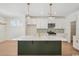 Modern kitchen boasts white cabinets, stainless appliances, a green backsplash, and a large island at 2624 Hillbourne Loop, North Myrtle Beach, SC 29582