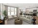 Cozy living room featuring a neutral sofa, large windows, and an open layout leading to the kitchen at 2624 Hillbourne Loop, North Myrtle Beach, SC 29582