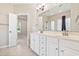 Bright bathroom features a double sink vanity with white cabinets, neutral tile floors, and access to the main bedroom at 765 Ashley Manor Dr., Longs, SC 29568