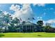 Classic style clubhouse with American and community flagpoles and statue on a well-manicured lawn at 765 Ashley Manor Dr., Longs, SC 29568