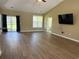 Open living area with hardwood floors, large windows, and access to a sliding glass door and kitchen at 1139 Parish Way, Myrtle Beach, SC 29577