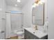 Bathroom with a shower/tub combo, gray vanity with gold fixtures, and a framed mirror at 210 26Th Ave. S, Myrtle Beach, SC 29577