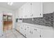 White kitchen with ample cabinetry and a tile backsplash at 4502 Eyerly St., North Myrtle Beach, SC 29582