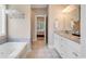 Well-lit bathroom featuring double sinks with granite countertops and a large soaking tub at 613 Lee Ave., Murrells Inlet, SC 29576