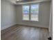 Cozy bedroom featuring wood-look flooring, pond views, and neutral decor at 1240 Winding Creek Way, Myrtle Beach, SC 29588