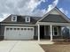Charming home featuring a two-car garage, dormer windows, and covered entryway with brick base columns at 1240 Winding Creek Way, Myrtle Beach, SC 29588