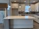Bright kitchen featuring white cabinets, a gray backsplash, a large island with quartz countertop and pendant lighting at 1240 Winding Creek Way, Myrtle Beach, SC 29588