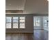 Bright living room with many windows providing a pond view, wood-look flooring, and modern trim at 1240 Winding Creek Way, Myrtle Beach, SC 29588