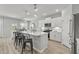 Modern kitchen features white cabinets, stainless steel appliances, an island with bar seating, and wood-look floors at 1320 Winding Creek Way, Myrtle Beach, SC 29588