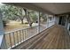 Relaxing back porch with wooden floors, white railings, and views of the lush surroundings at 187 Alston Rd., Pawleys Island, SC 29585