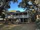 Exterior view of raised beach house with large covered porch and ample parking at 187 Alston Rd., Pawleys Island, SC 29585
