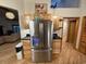 Stainless steel refrigerator with black countertops, wood cabinets and a view of living room at 187 Alston Rd., Pawleys Island, SC 29585
