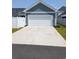 Detached two-car garage with white doors and a well-kept surrounding lawn at 2023 Singing Palm Loop, Little River, SC 29566