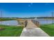 Scenic lake view with a wooden pier, fountain, and lush green surroundings at 2023 Singing Palm Loop, Little River, SC 29566