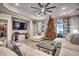 Spacious living room features a ceiling fan, recessed lights, luxury vinyl flooring, and a decorated Christmas tree at 2023 Singing Palm Loop, Little River, SC 29566