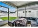 Enclosed porch with cushioned outdoor seating, providing a relaxing outdoor space at 2023 Singing Palm Loop, Little River, SC 29566
