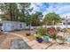 Landscaped backyard with a shed, seating area, and a variety of plants and flowers at 405 Cypress Springs Way, Little River, SC 29566