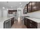 Open kitchen view showcasing granite counters, stainless steel appliances, and dark wood cabinetry at 405 Cypress Springs Way, Little River, SC 29566