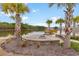 Community lake with a fire pit, pier, and palm trees, creating a serene outdoor space at 405 Cypress Springs Way, Little River, SC 29566