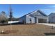 A blue home exterior featuring a manicured lawn and landscaping, showcasing the property's curb appeal at 405 White Willow Way, Longs, SC 29568