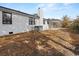 View of the rear exterior with brick, dark trim, chimney, and covered patio. Small yard at 412 E Melrose St., Mullins, SC 29574