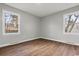 Bright, neutral bedroom featuring hardwood floors and natural light from two windows at 412 E Melrose St., Mullins, SC 29574