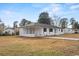 A single-story brick home with dark trim features a covered porch and yard at 412 E Melrose St., Mullins, SC 29574