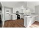 Bright updated kitchen features white cabinets, modern appliances, and wood-look floors at 412 E Melrose St., Mullins, SC 29574