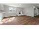 Bright living room featuring wood floors, an adjacent kitchen, and a cozy brick fireplace at 412 E Melrose St., Mullins, SC 29574