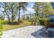 Serene backyard featuring a lush lawn, stone patio, and mature trees for outdoor enjoyment at 775 Plantation Dr. # 59, Little River, SC 29566